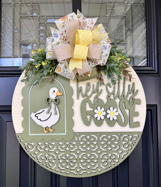 Handmade Hey Silly Goose wooden door hanger featuring a vintage white goose, sage green accents, laser-cut details, floral bow, and greenery on an 18-inch round spring front door sign.