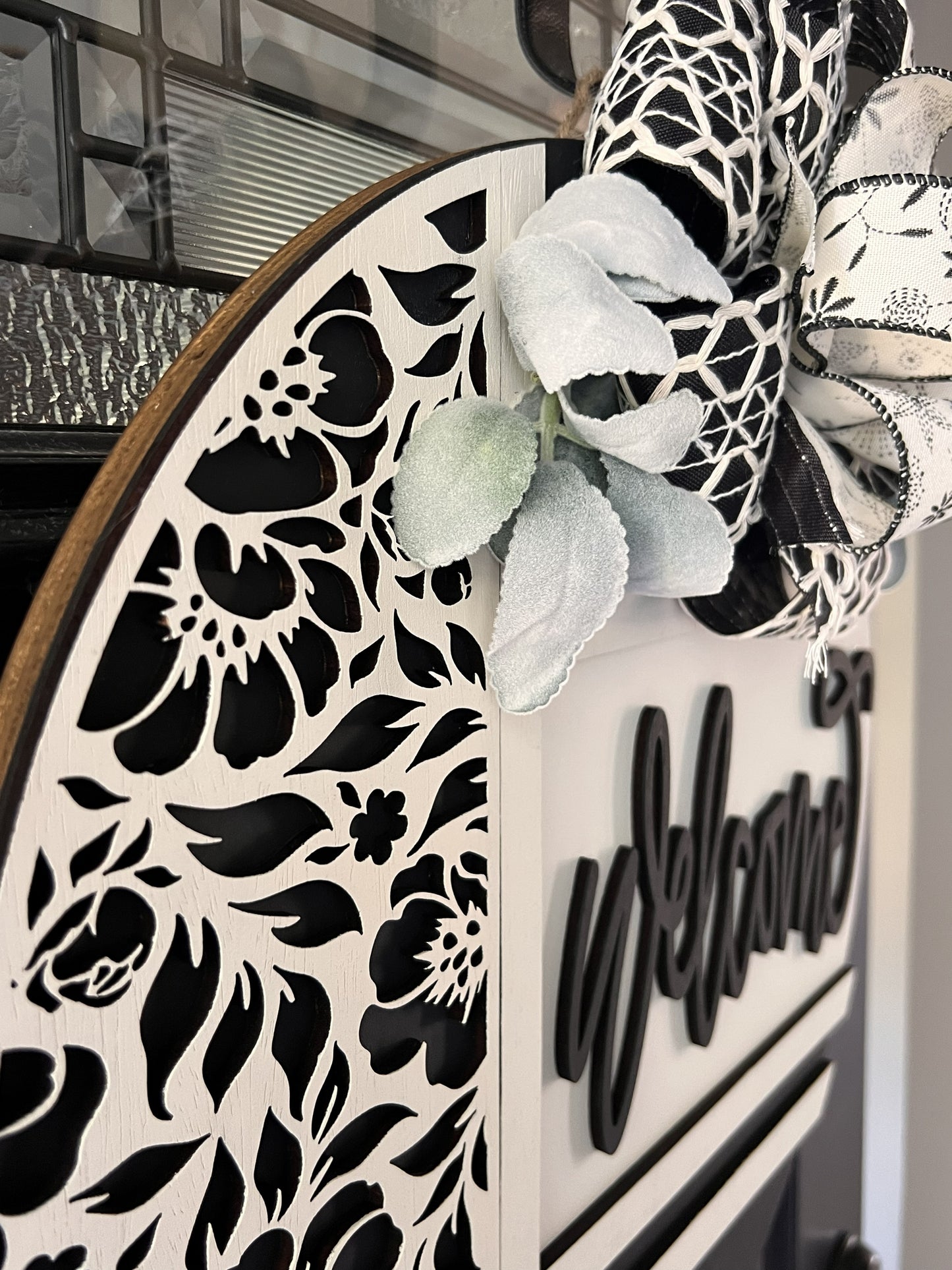 Decorative wreath with floral patterns and a flower birwood overlay- with 'Welcome' text.