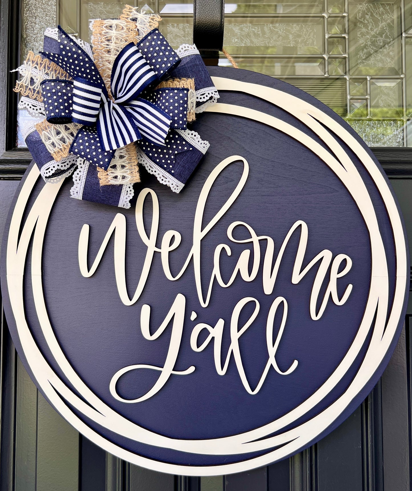 Welcome Y'all circle sign close up of cream script lettering
