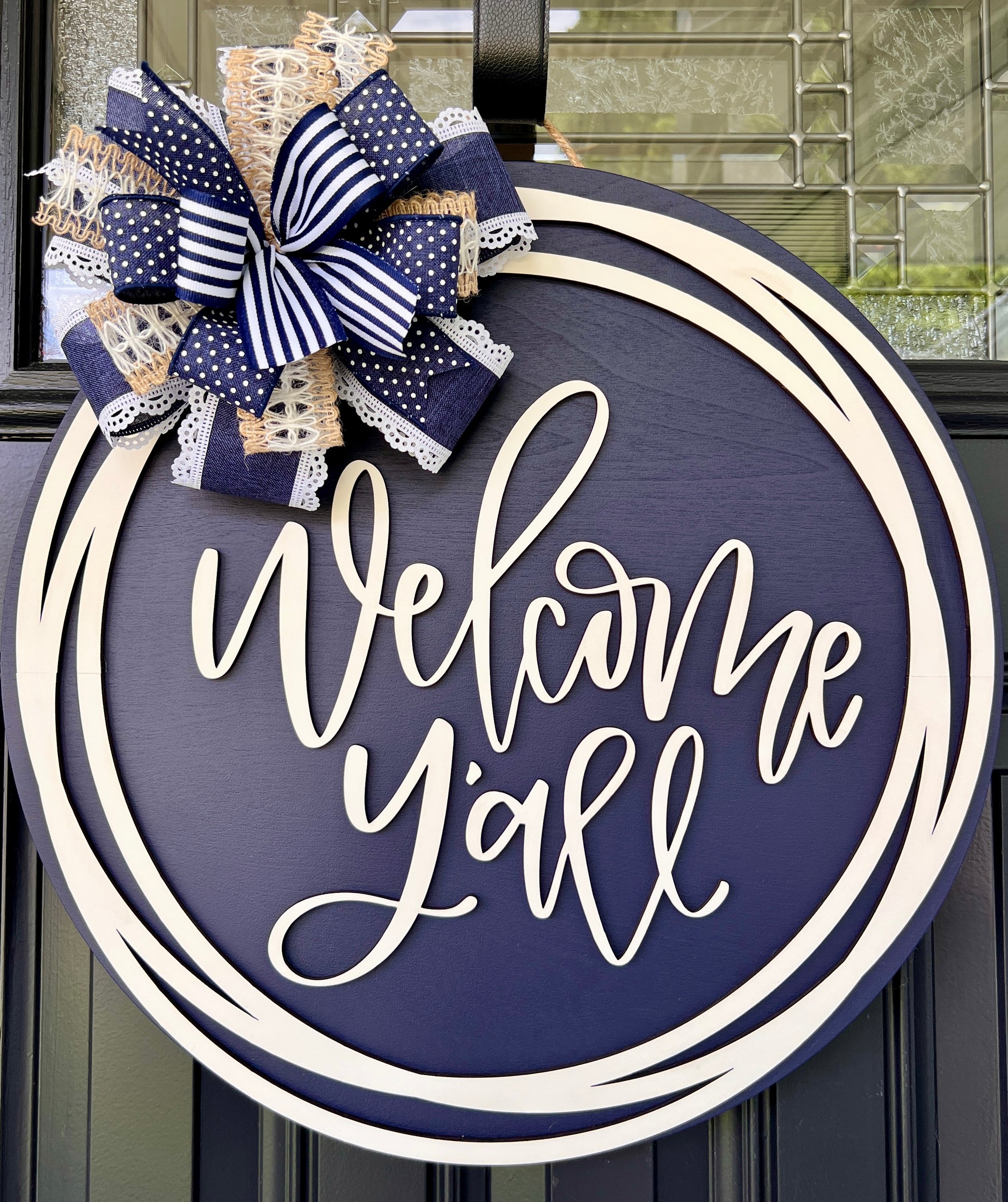 Welcome Y'all circle sign close up of cream script lettering