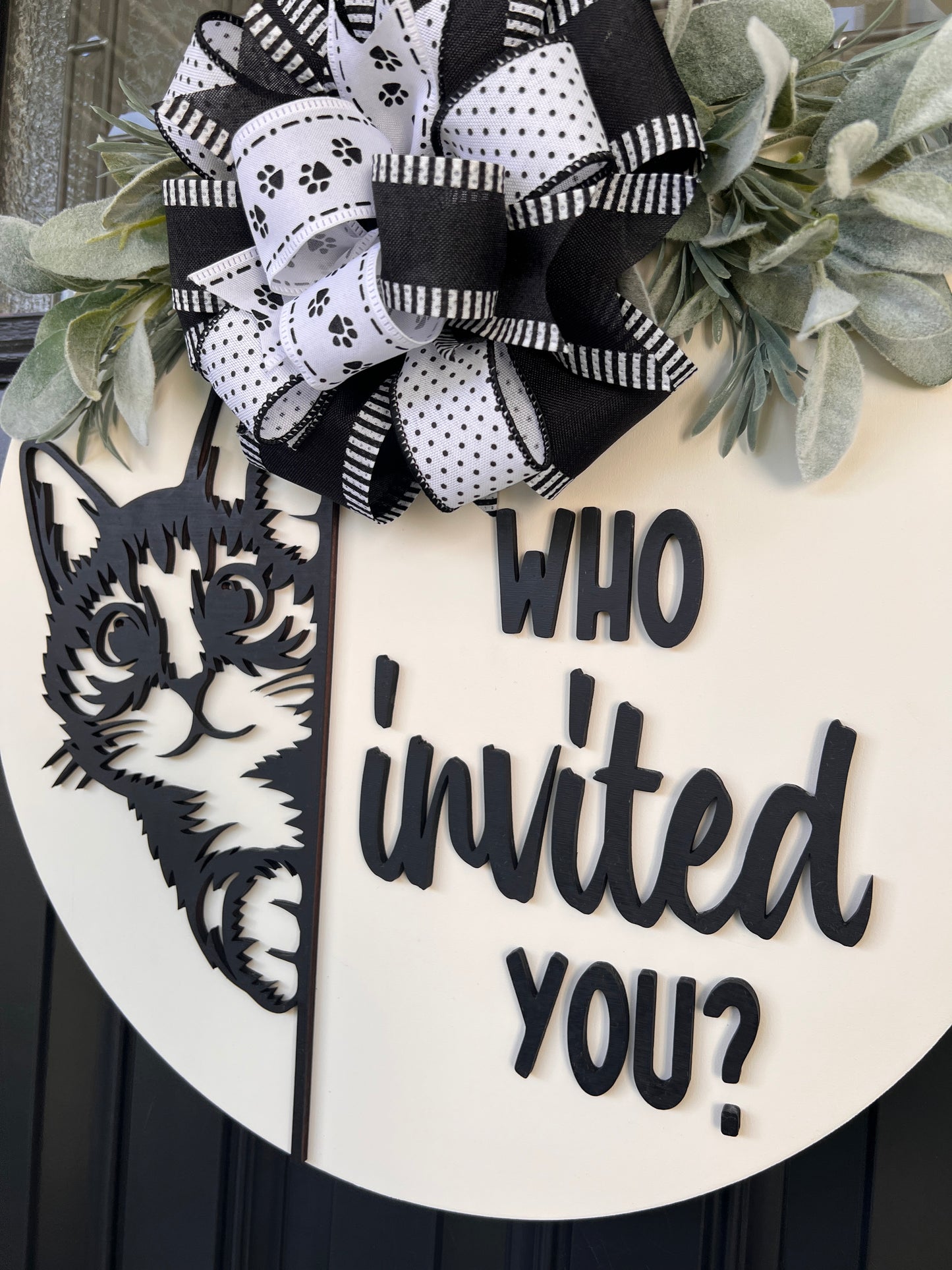 Funny cat door hanger featuring a black cat peeking around the edge and the phrase "Who Invited You?" displayed on a front door.