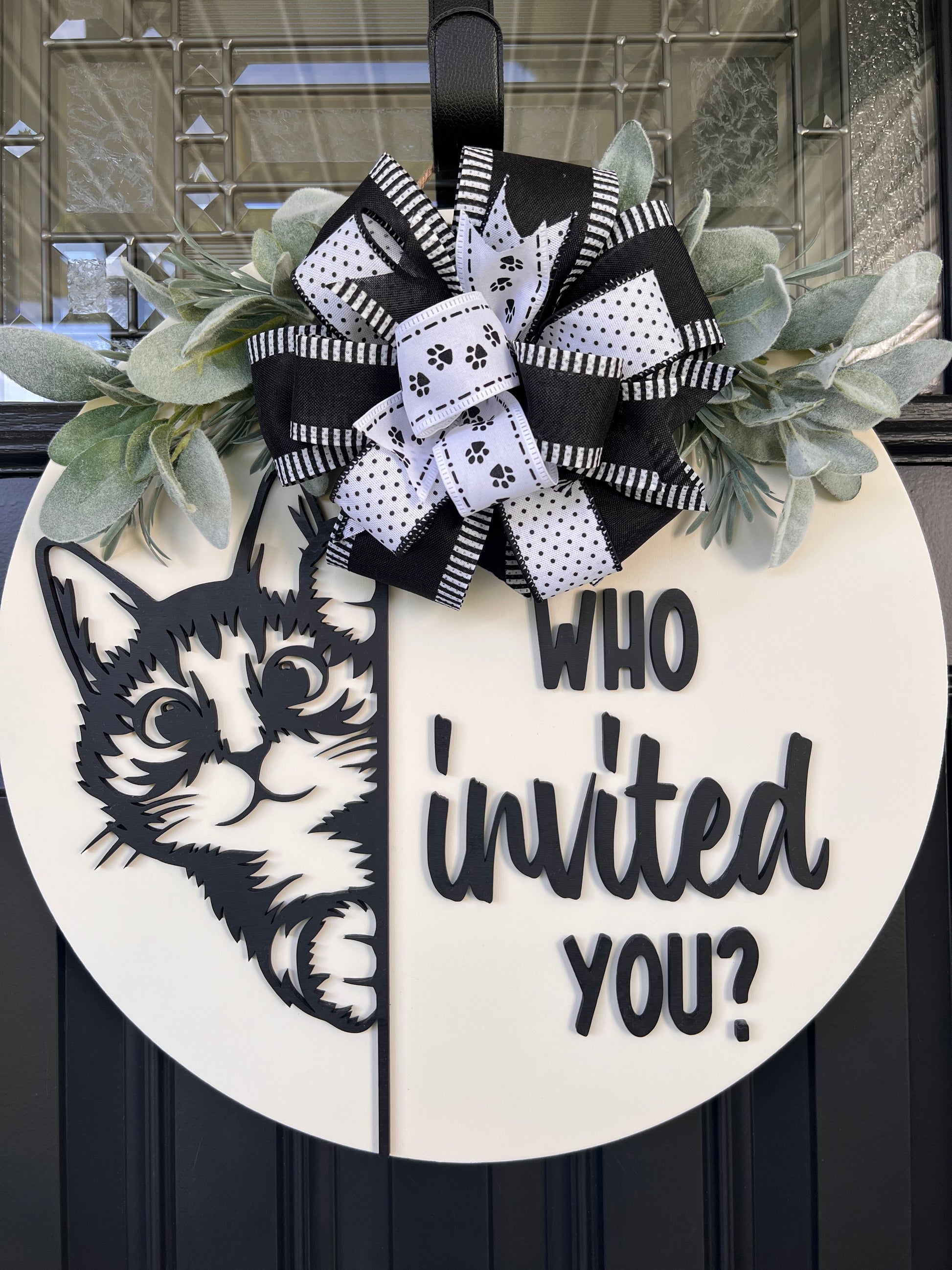Funny cat door hanger featuring a black cat peeking around the edge and the phrase "Who Invited You?" displayed on a front door.