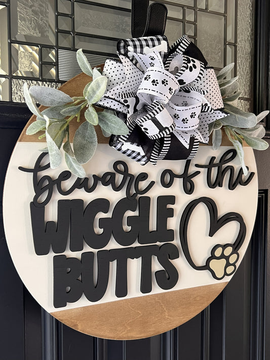 Birchwood Doorhanger with text 'Beware of the Wiggle Butts' and decorative bows on a door.