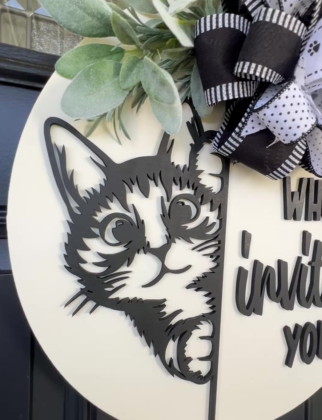 Funny cat door hanger featuring a black cat peeking around the edge and the phrase "Who Invited You?" displayed on a front door.