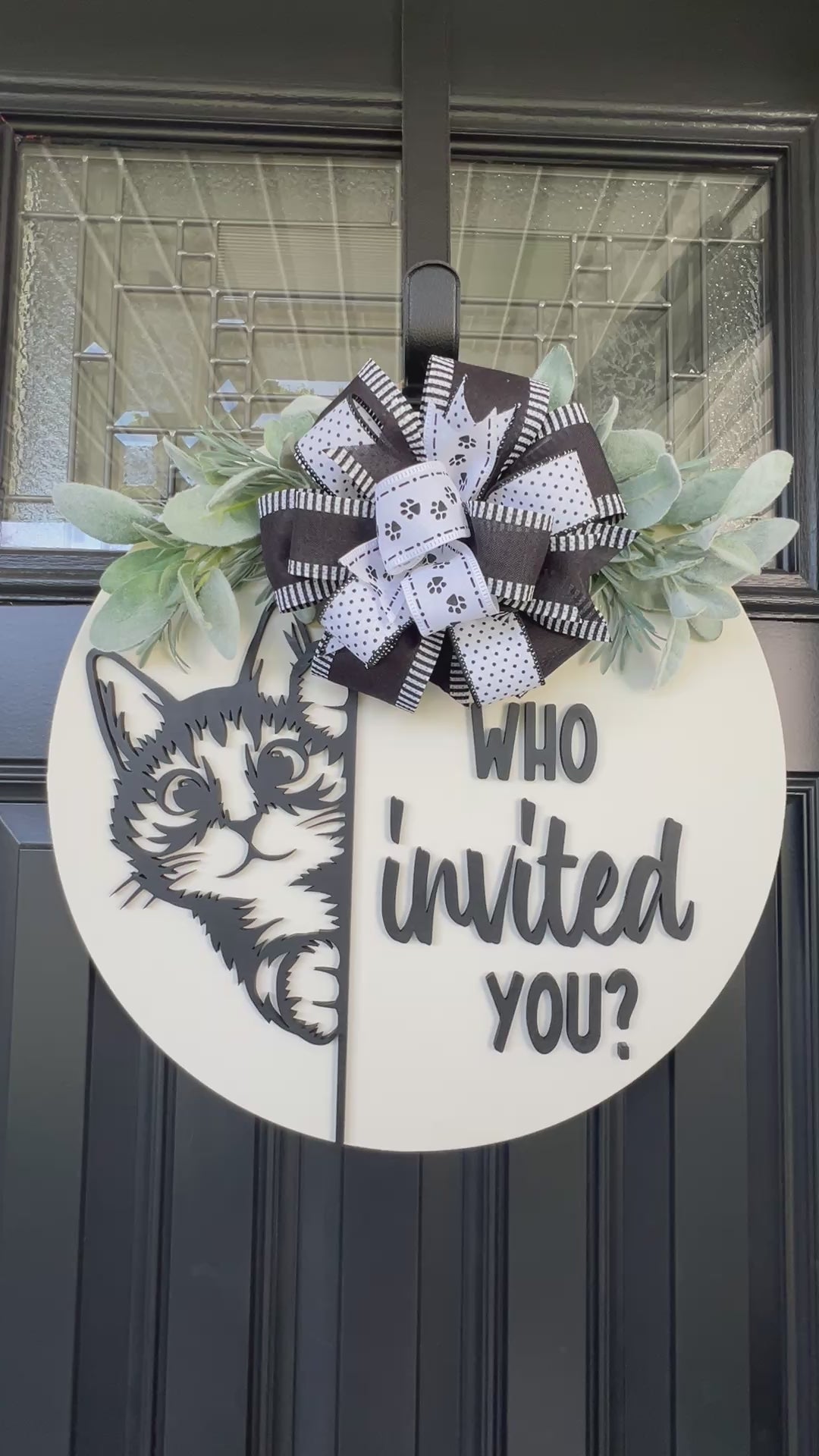 Funny cat door hanger featuring a black cat peeking around the edge and the phrase "Who Invited You?" displayed on a front door.