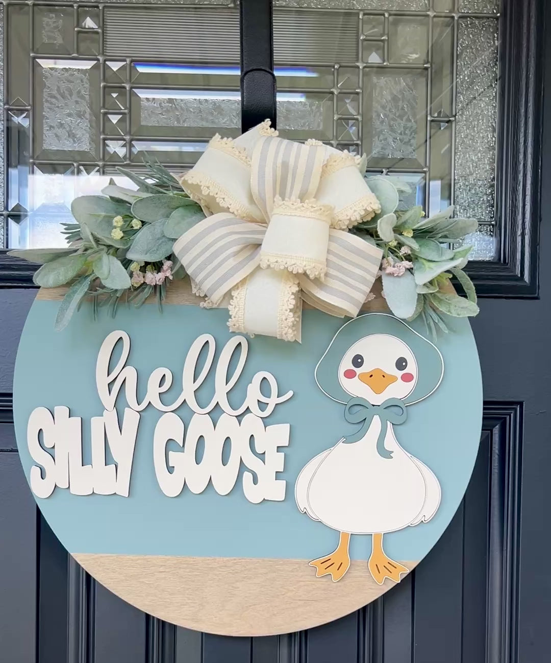 Handmade Hello Silly Goose door hanger with layered lettering, blue background, farmhouse goose illustration, greenery, and designer bow.movie 