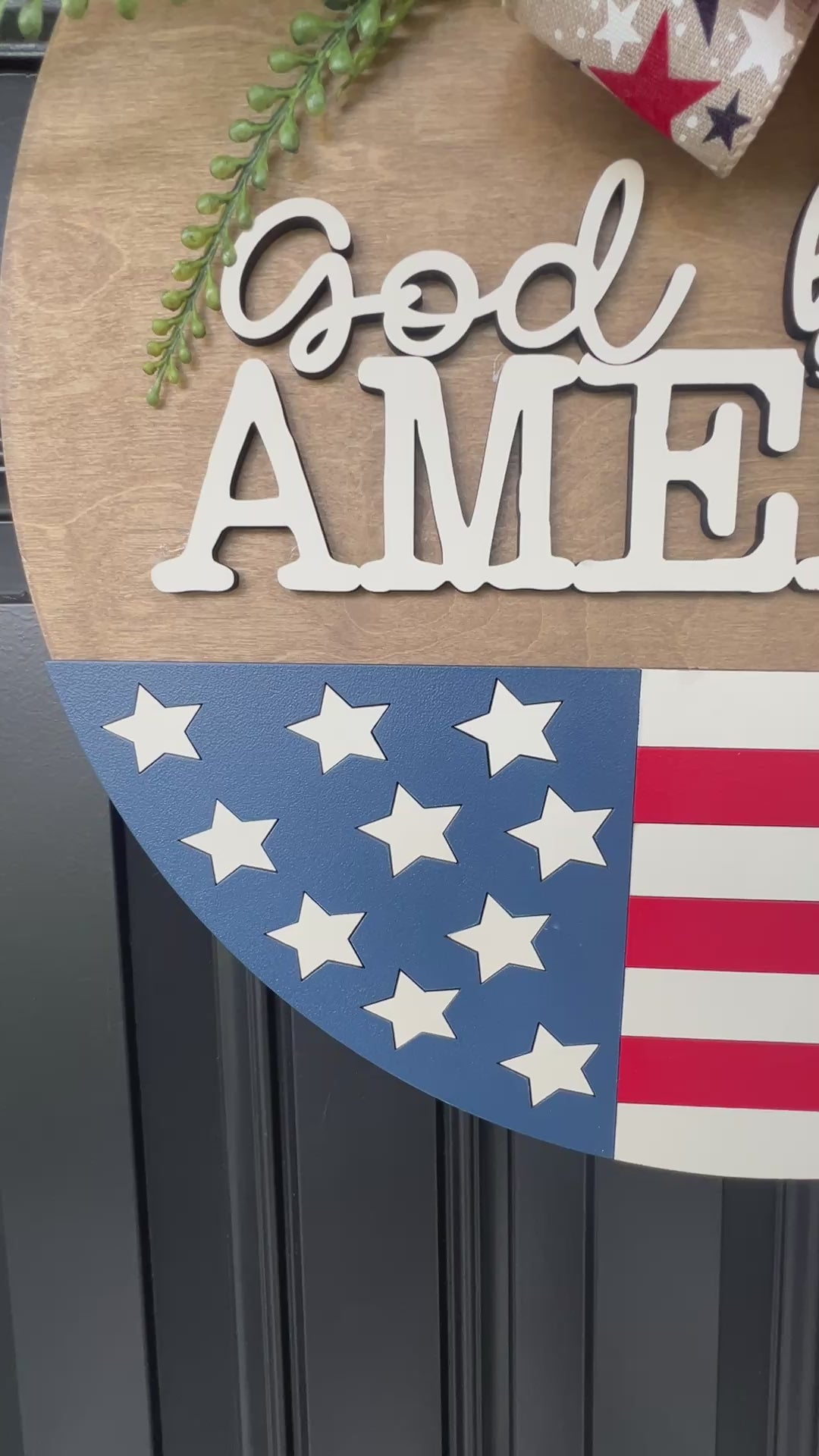 Decorative door hanger with 'God bless America' text and American flag design.