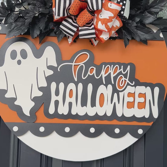 Happy Halloween ghost door hanger on black front door with orange birchwood round and layered ghost print bow with black leaf sprays