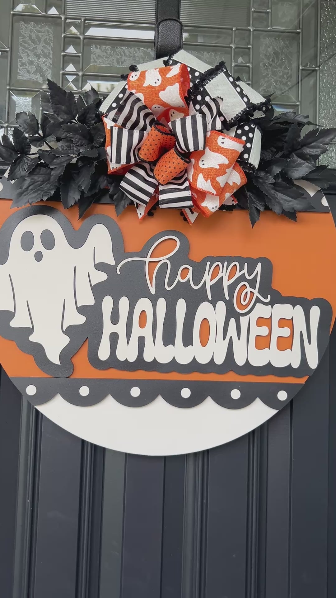 Happy Halloween ghost door hanger on black front door with orange birchwood round and layered ghost print bow with black leaf sprays