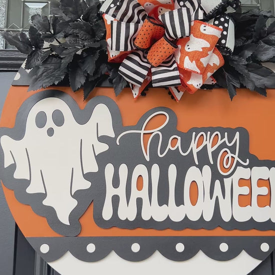 Happy Halloween ghost door hanger on black front door with orange birchwood round and layered ghost print bow with black leaf sprays