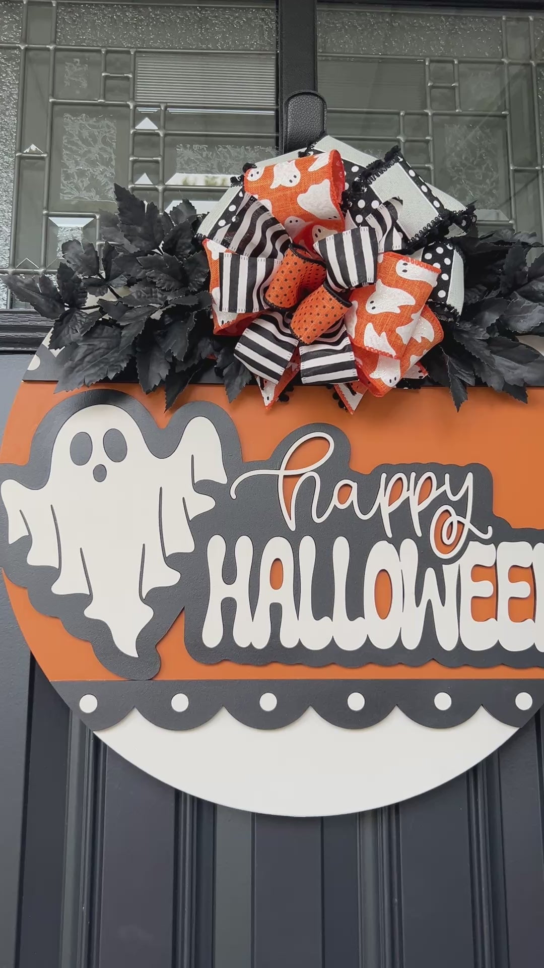 Happy Halloween ghost door hanger on black front door with orange birchwood round and layered ghost print bow with black leaf sprays