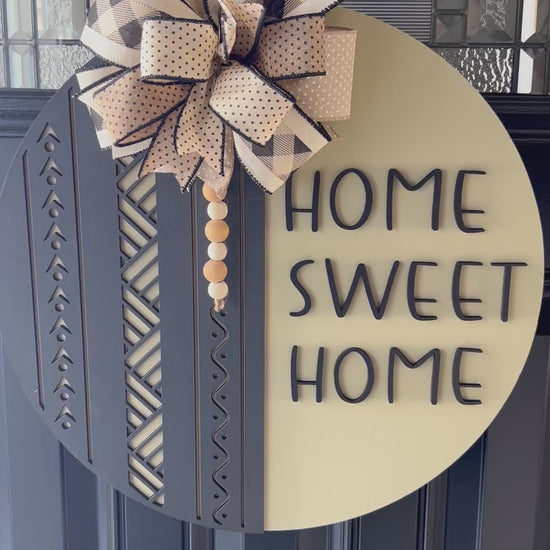 Home sweet home door hanger with neutral oatmeal color and black boho farmhouse design, handcrafted wooden front door decor- detailed close up 