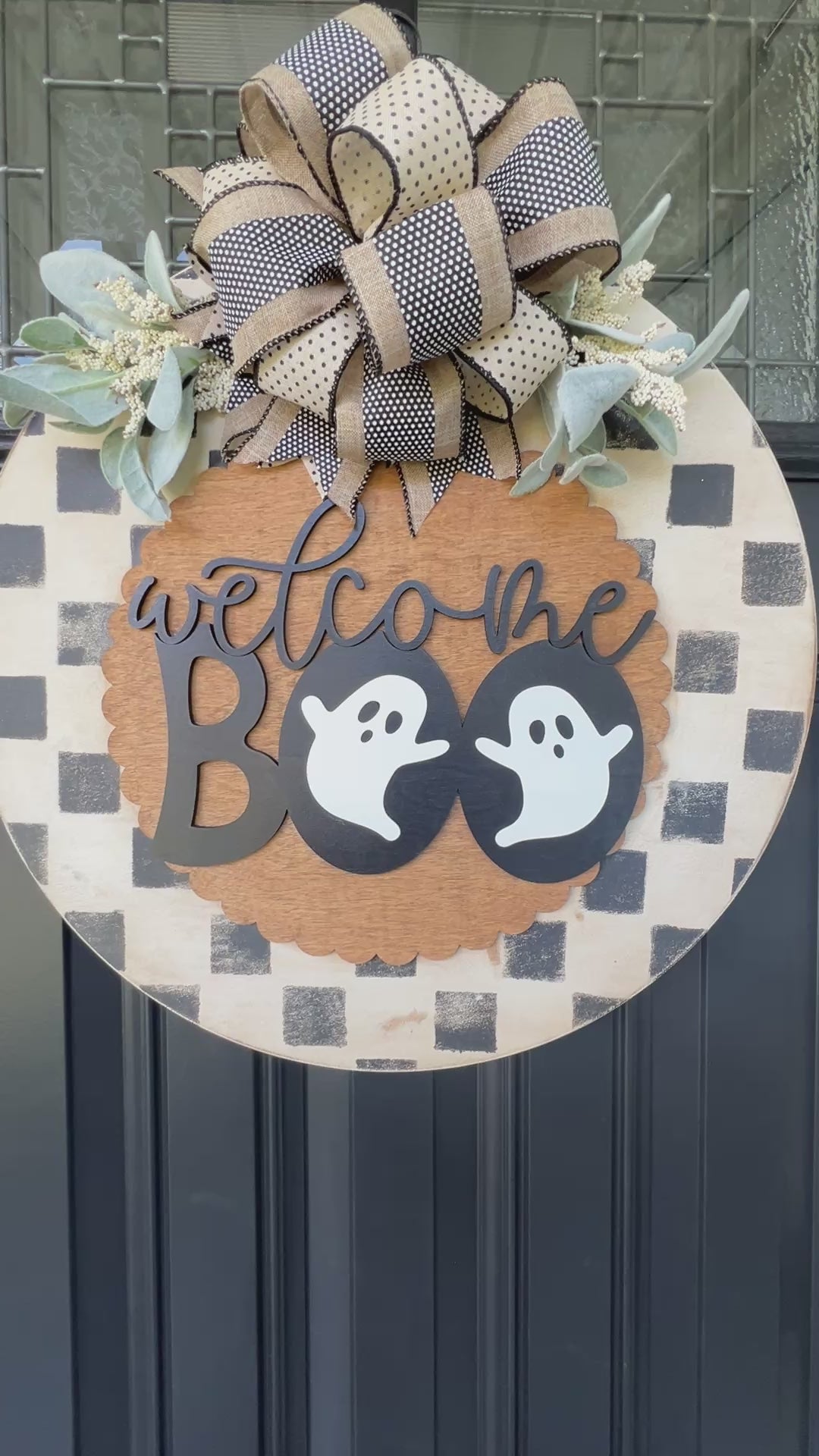 Handmade Welcome Boo Halloween door hanger with ghost accents, black and cream checkered background, layered wood lettering, designer bow, and fall front porch décor.