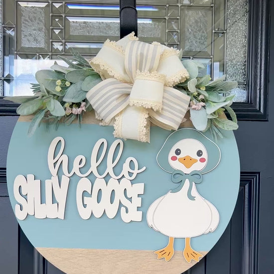 Hello Silly Goose.Product video. Blue background, spring floral accent and lace accent bow. 