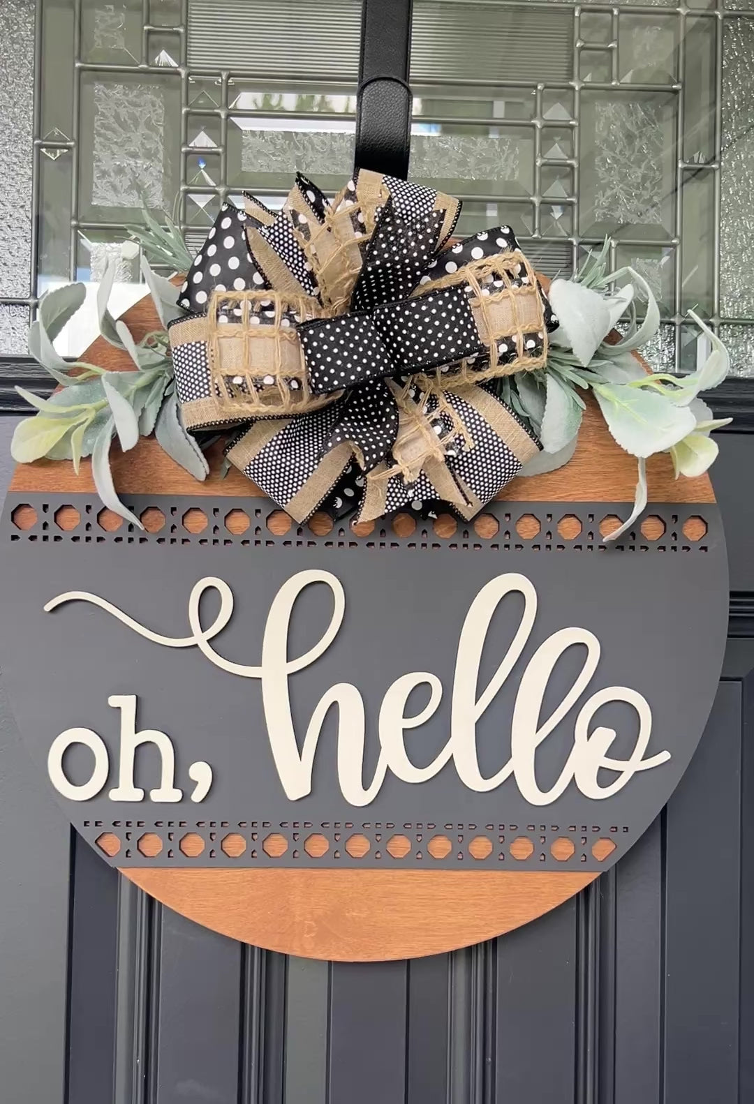 Close-up of premium black and cream designer bow with greenery on handcrafted wooden door sign.
Front view of modern farmhouse Oh Hello wooden welcome sign with dimensional lettering.
