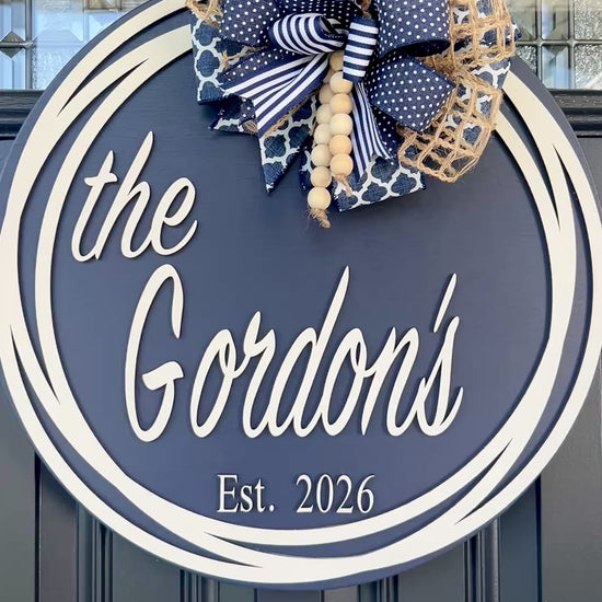 Round family name door hanger customized with last name and established date.