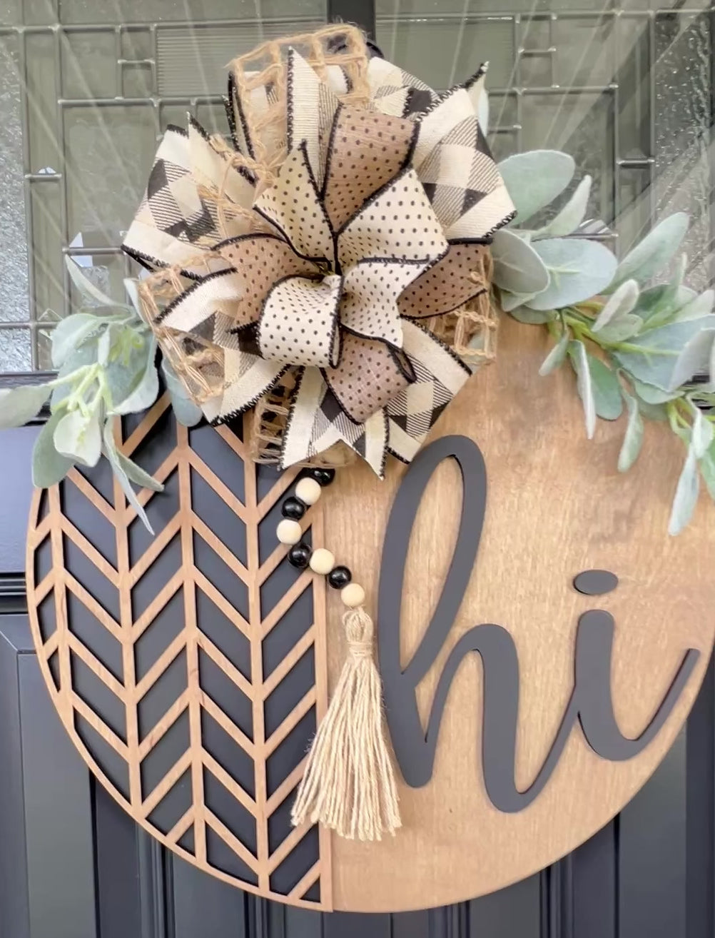 “Video showing handmade neutral ‘Hi’ layered wood door hanger displayed on a black front door”