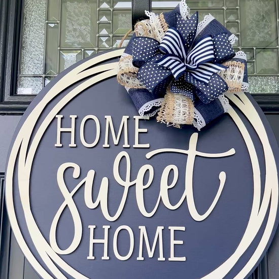 Home Sweet Home navy blue circle framed door hanger on black front door with layered navy polka dot grid and jute burlap bow