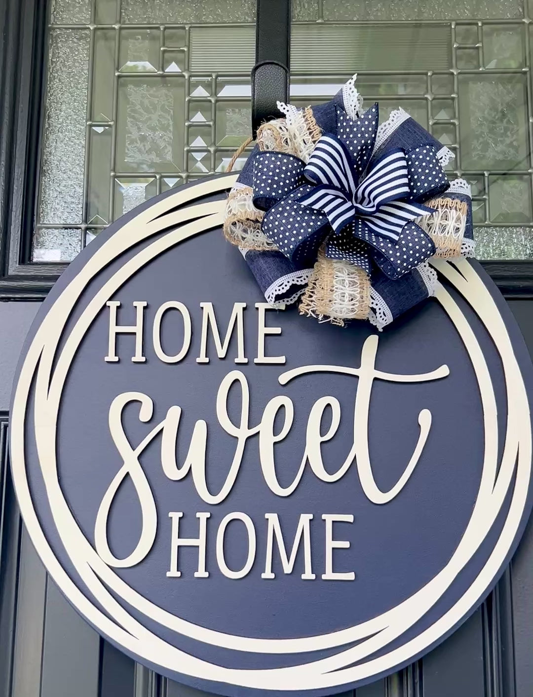 Home Sweet Home navy blue circle framed door hanger on black front door with layered navy polka dot grid and jute burlap bow