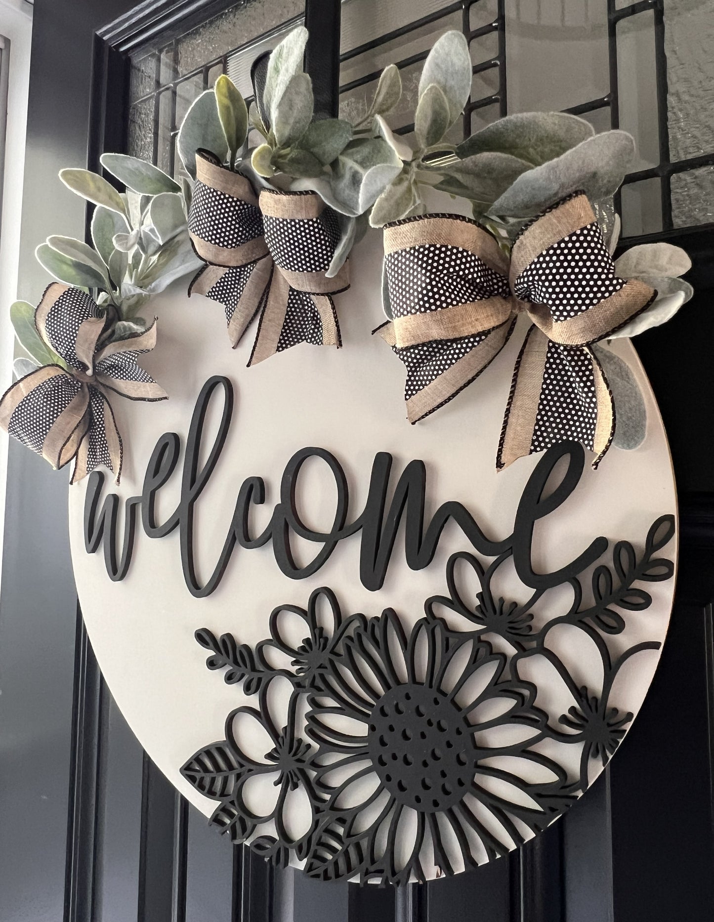 Elegant neutral floral welcome door hanger with layered wood design and greenery accents.  18” round front door decor.
